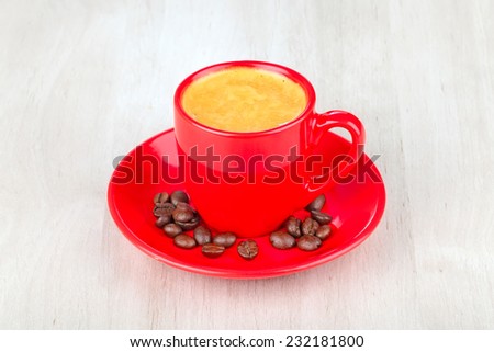 red coffee cup and coffee beans  on wooden table