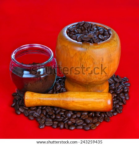 Mortar and pestle with black coffee and coffee beans on red background