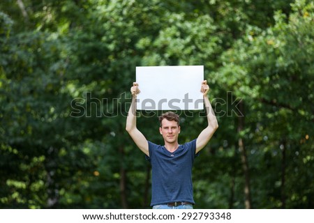 Man holding white board in the park
