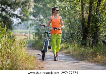 Women walking with bicycle in the forest