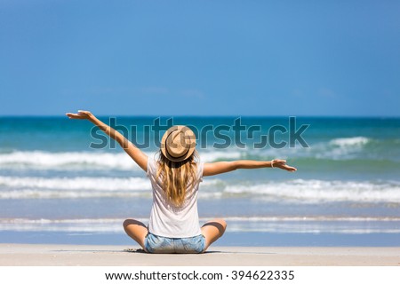 Happy woman traveler relaxing on a perfect beach