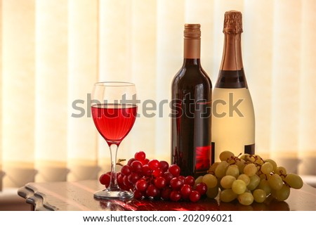 Red vine, champagne, glass of vine and grapes.