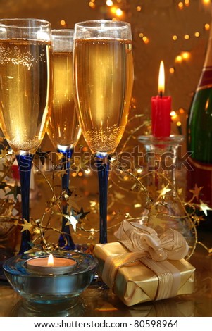 Champagne in glasses,gift box,candle lights and twinkle lights on background.