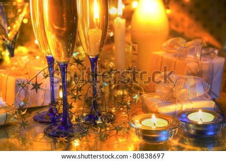 Champagne in glasses,bottle,candle lights,gifts and twinkle light on background.