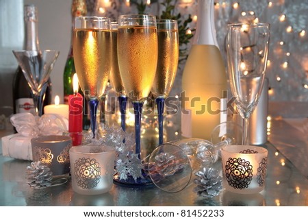 Champagne in glasses,candle lights,bottle and twinkle lights on background.