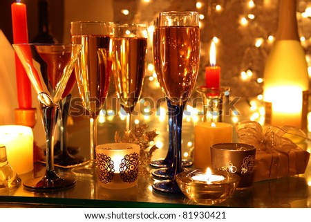 Champagne in glasses,bottle,candle light and twinkle light on background.