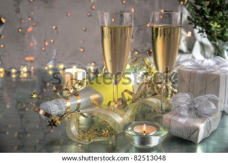Champagne in glasses,bottle,gifts and twinkle lights on background.