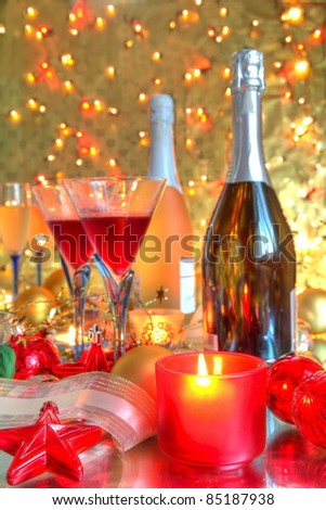 Red wine in glasses ,candle lights,bauble on golden background with twinkle lights.