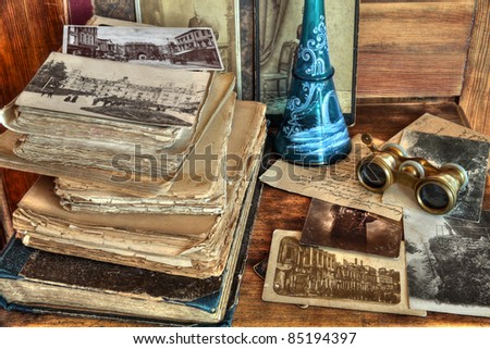 Old postcards, photos, correspondence,books,decanter and opera glasses on wooden background.