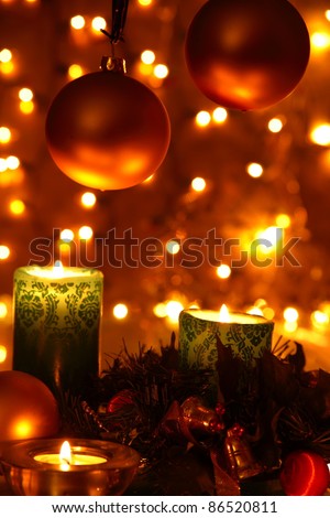 Christmas decoration with baubles,candle lights,green twig and twinkle lights on background.