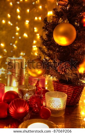 Christmas decoration with christmas tree, baubles, candle lights and twinkle lights on golden background.