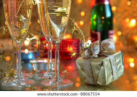 Closeup of champagne in glasses,gift,candle lights and twinkle lights on background.