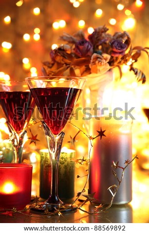 Red wine in glasses,candle lights,flowers and twinkle light background.