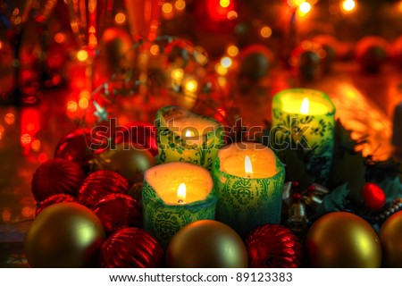 Christmas decoration with baubles, candle lights, green twig on background with twinkle lights.