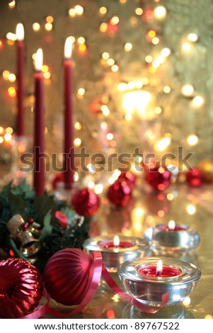 Christmas decoration with baubles,candle lights,green twig and twinkle lights on golden background.
