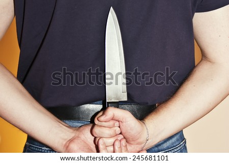 Sharp big knife behind the back