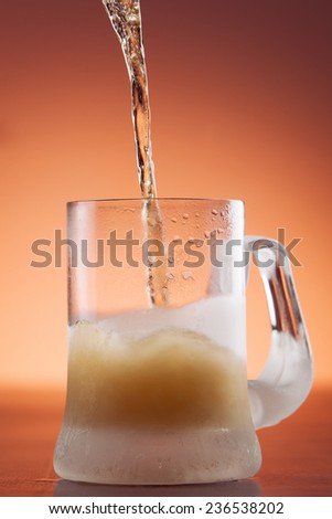 Cold beer pouring in a chilled mug