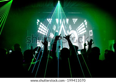Nightclub man with mobile phone recording lasers at party rave silhouette