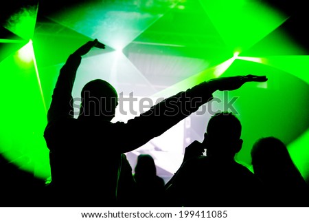 Man with hands in the air at nightclub party rave