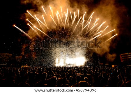 DJ Concert Festival with Special Effects Fireworks over the Silhouette Crowd Backlit