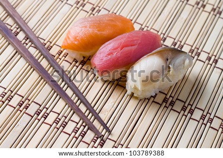 Japanese tradition food, Sushi  made of salmon, tuna  and mackerel with  rice on wood  bamboo  mat with chopsticks