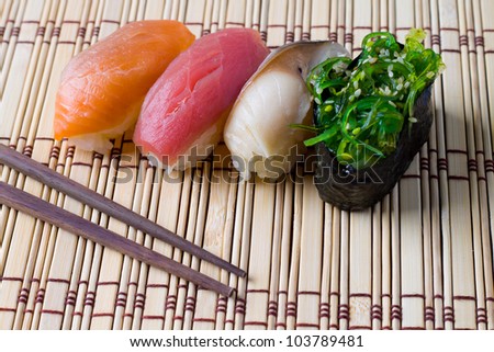 Japanese tradition food, Sushi  made of salmon, tuna  and mackerel with  rice on wood  bamboo  mat with chopsticks