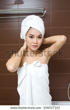 Beauty female portrait with a towel wrapped in the bathroom