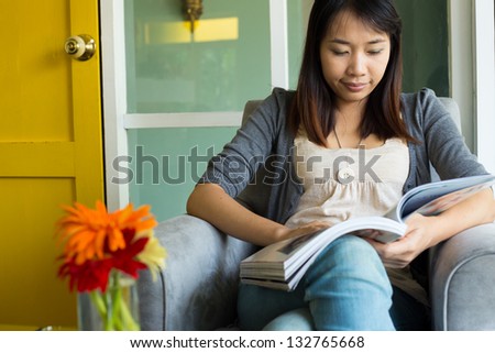 Woman reading a book on sofa in cafe restaurant