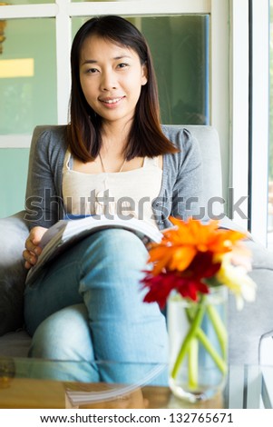 Woman reading a book on sofa in cafe restaurant