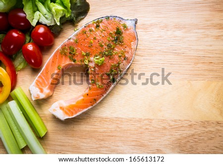 Raw fresh Salmon steak on wood  cutting board  with vegetables