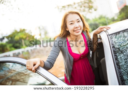 Happy woman with her car, door opened.