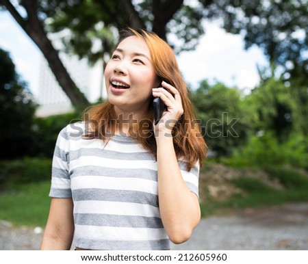 Young asian woman talking on phone at outdoor