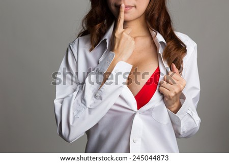 Sexy asian woman showing her sexy breast in red lingerie with shirt opened by hand on white background
