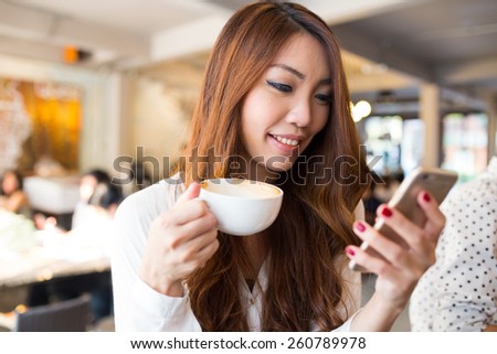 Young woman texting or using smartphone and drinking coffee in the cafe, City lifestyle, cafe lifestyle, Modern life.