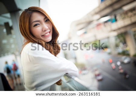 Portrait of asian woman in the city, smiling at outdoor in evening with city background