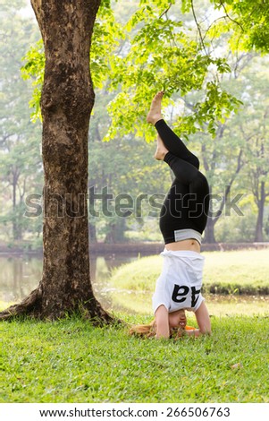Young asian woman doing yoga in the  green natural park