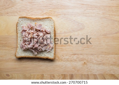 Canned tuna meat on whole wheat bread on wood background, Healthy eating concepts.