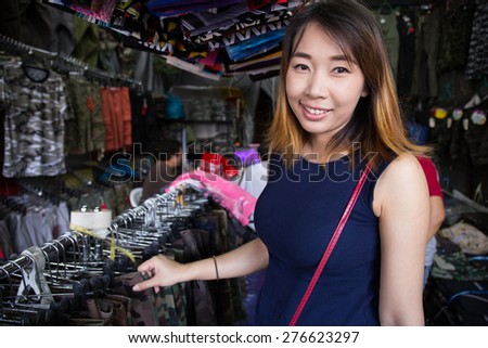 Young asian girl in local shop buying clothes