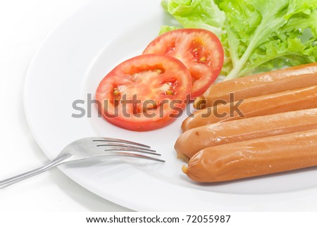 Sausage with vegetables in plate with fork