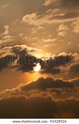 Golden sky at dusk with black clouds and The shining sun