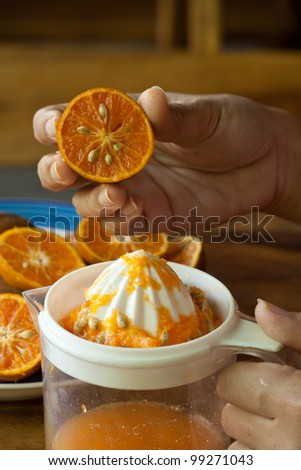 Hand squeezing an orange for fresh juice
