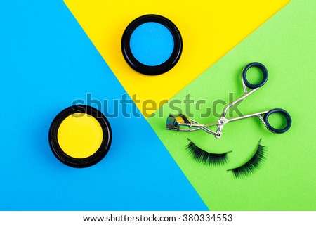 cosmetics for makeup. bright blue background with green eyelashes glamorous and trendy