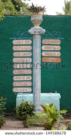 Spanish Sign Post at a Cuban Resort - A Spanish sign post at a Cuban resort, pointing the way to various areas