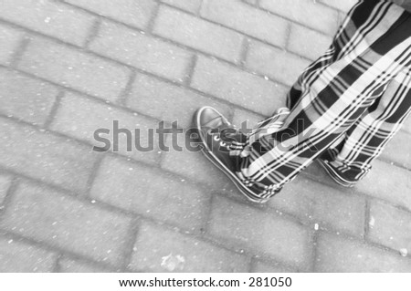 Legs in gym shoes on sidewalk