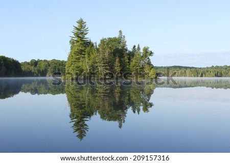 Island and Mirror Reflection on a Still Lake - Haliburton, Ontario, Canada