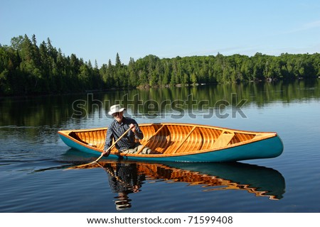 Paddling A Canoe. paddling cedar canoe on a