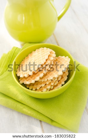Waffles in the green ceramic bowl on the green napkin