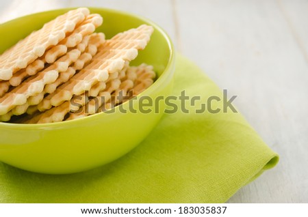 Waffles in the green ceramic bowl on the green napkin closeup