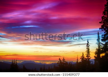 A beautiful colorful epic sunrise over the city lights of Boulder Colorado looking out from high up on the Rocky Mountains Rollins Pass and the Continental Divide west of Boulder.