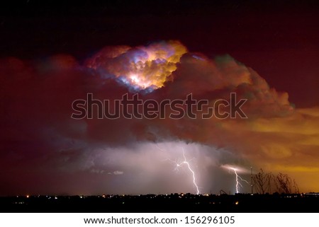 Colorful thunderstorm thunderhead lit up with lightning bolts striking in Boulder County Colorado.